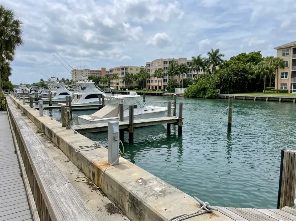 Illustration of a small marina on the Intracoastal Waterway in Boynton Beach with sport-fishing boats at wooden docks and condos on the far bank