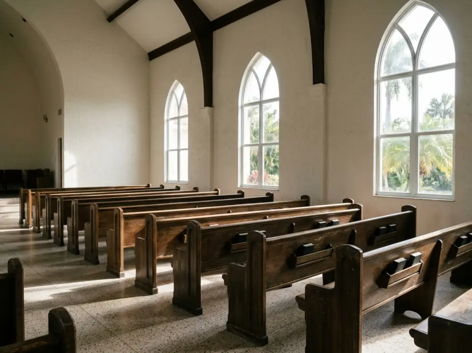 Illustration of rows of empty wooden pews in a bright South Florida church with tall windows and morning light