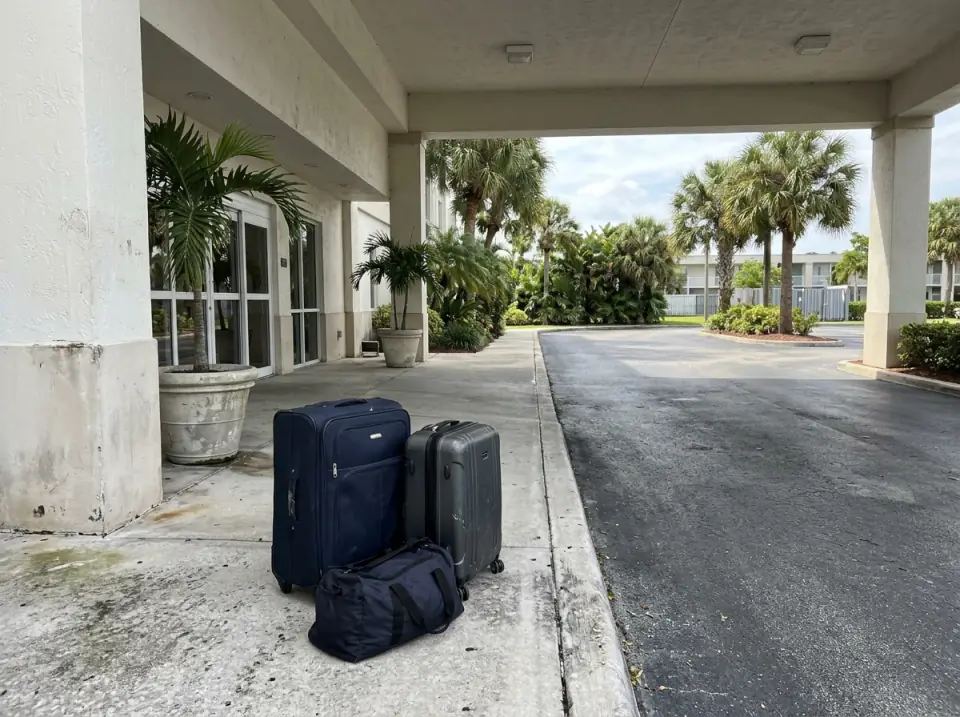 Illustration of two suitcases and a duffel bag waiting under the covered entrance of a low-rise hotel near the airport