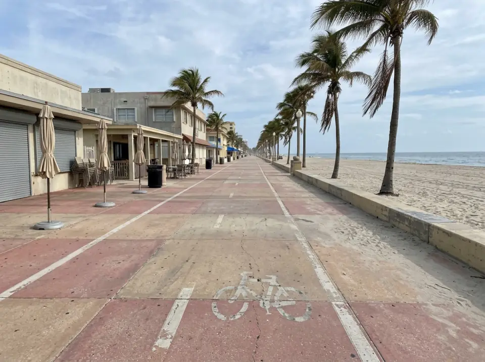 Illustration of the paved beachfront promenade at Hollywood Beach, with low beach buildings on one side and the sand and ocean on the other