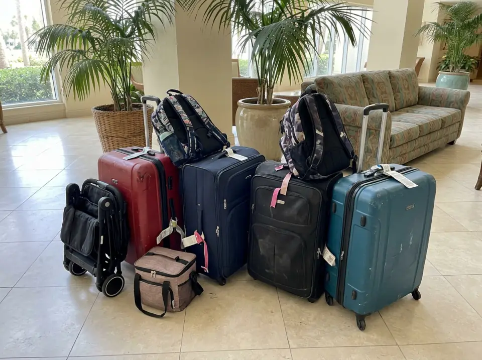 Illustration of a family's cruise luggage lined up on a hotel lobby floor: suitcases, backpacks, a folded stroller and a soft cooler bag