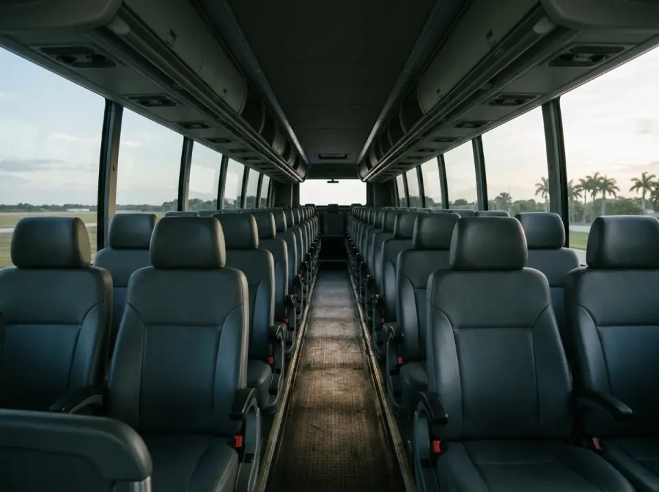 Illustration of the empty aisle of a modern motorcoach at dawn, grey reclining seats and overhead racks in soft light