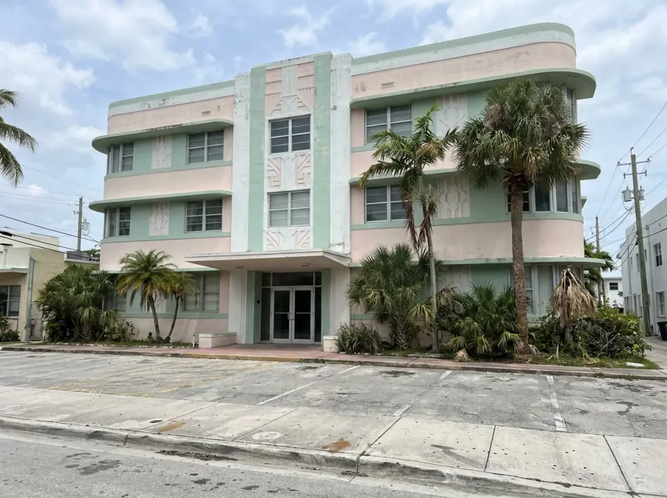 Illustration of a pastel Art Deco style building on a Miami Beach street with rounded corners, a short covered entrance and palms