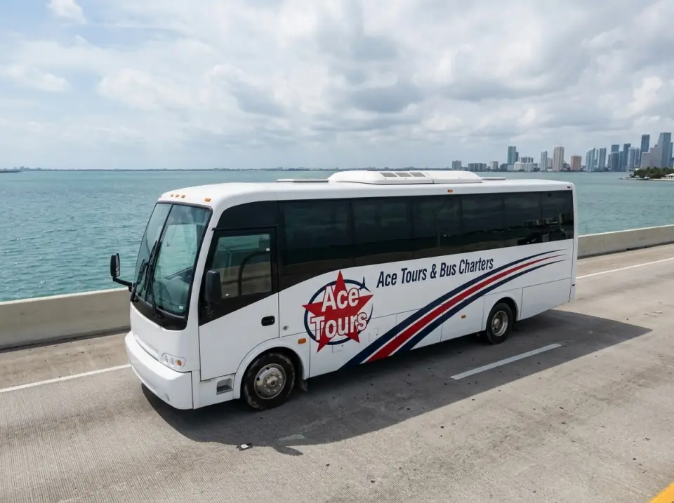Illustration of a white Ace Tours & Bus Charters minibus on a bridge across Biscayne Bay with the Miami Beach skyline ahead, seen from a low drone angle