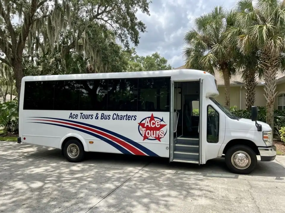 Illustration of a white Ace Tours & Bus Charters minibus waiting with its door open in a residential driveway in Stuart, Florida, under oak trees and palms