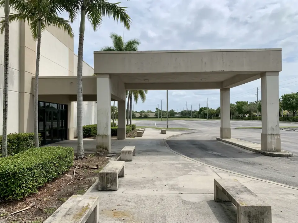 Illustration of the covered drop-off and benches at the entrance of a suburban church in Miramar, with palms and an empty parking lot
