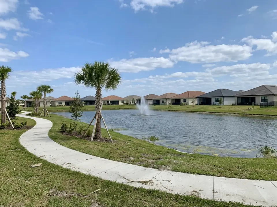 Illustration of a lake with a fountain, a curving walking path and young palms in a newer Port St. Lucie neighborhood